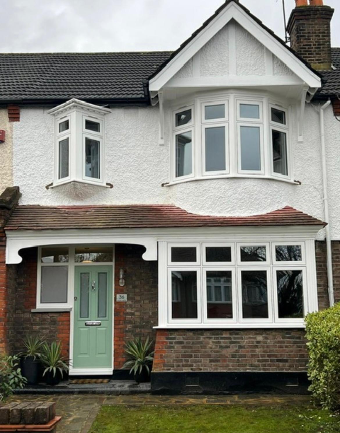 White rendered Surrey semi with two bay windows and a sage green composite door